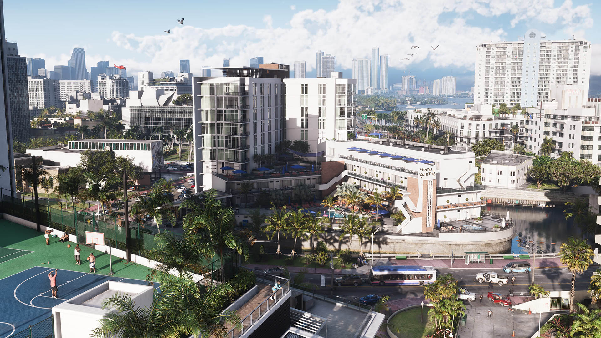 A vibrant cityscape featuring high-rise buildings, palm-lined streets, and a waterfront hotel labeled "Hotel Valetta," with people playing basketball on a rooftop court in the foreground—capturing the sunny, upscale urban atmosphere of Vice City in GTA 6.