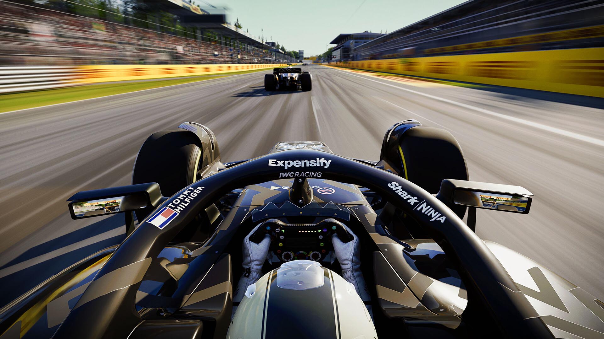 First-person cockpit view from an F1 car racing at high speed on a sunlit circuit in F1 25, showing hands on the steering wheel, rear wing ahead, and blurred grandstands creating a sense of motion.