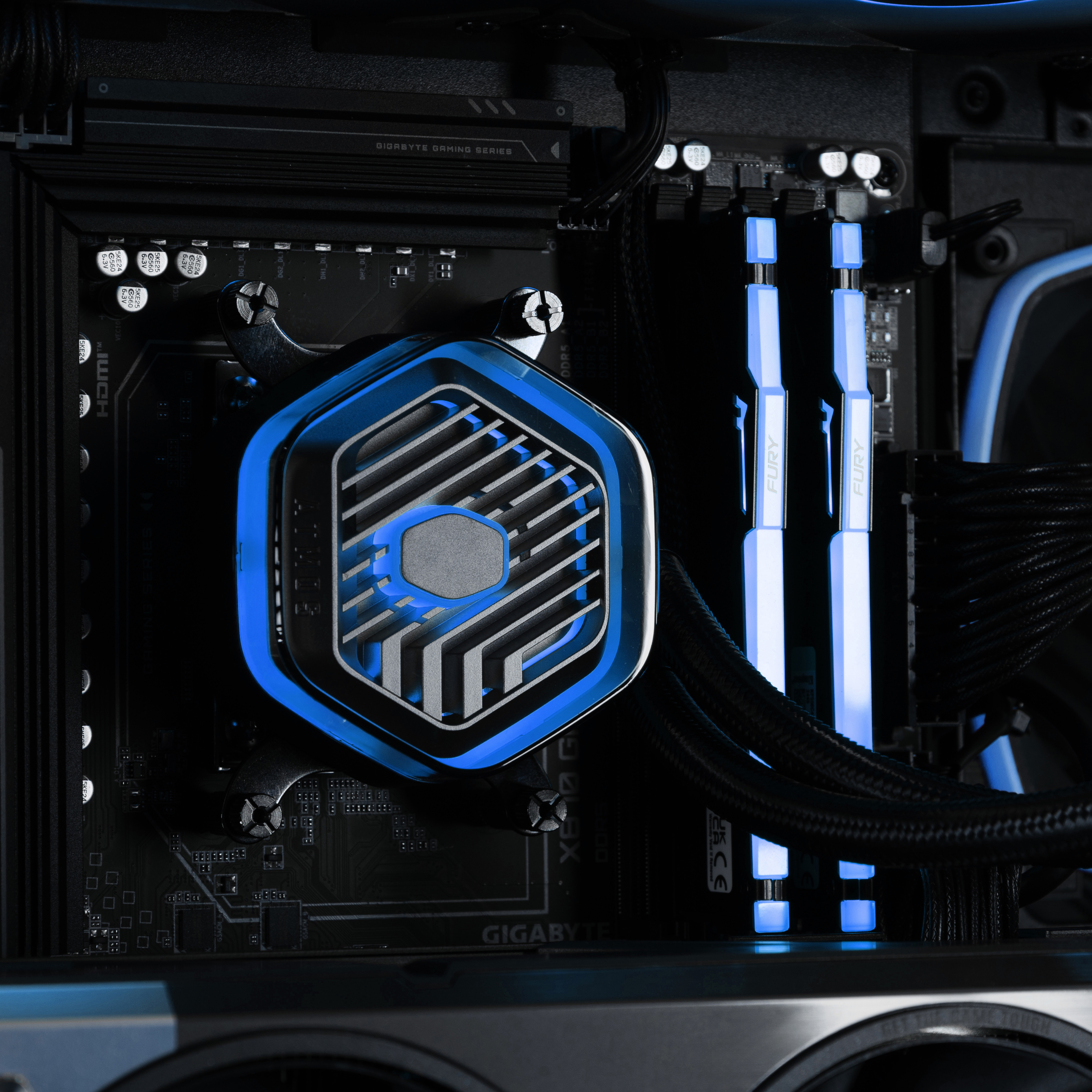 A closeup if the CPU pump and memory bathed in blue lights