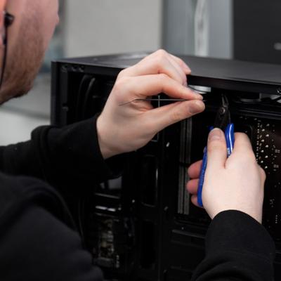A technician assembling a Chillblast PC, carefully working with internal components using precision tools, showcasing the meticulous craftsmanship involved in building high-performance computers.