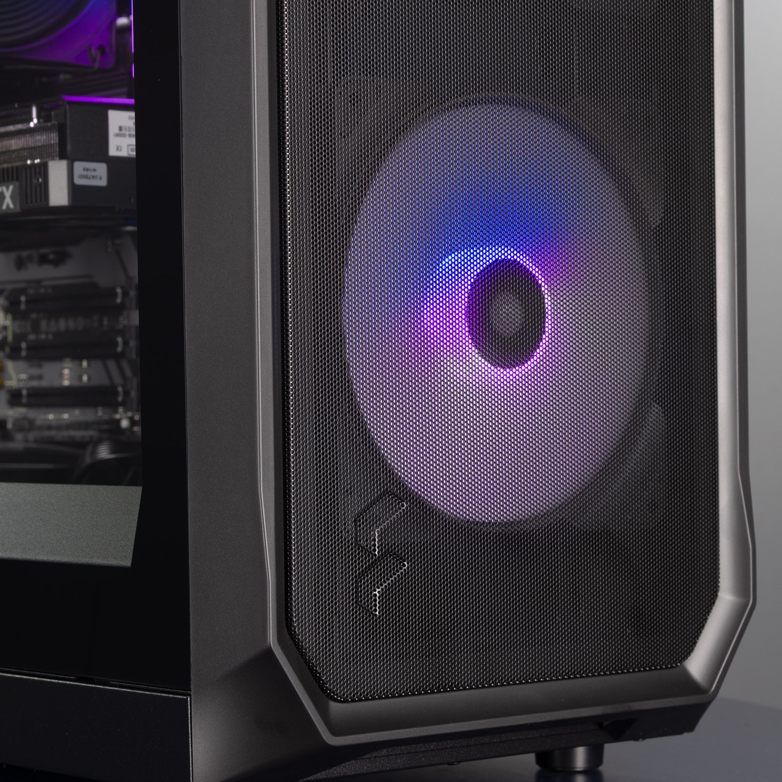 The front of the PC, showing the Fractal logo and one front fan lit up in a blue and purple gradient