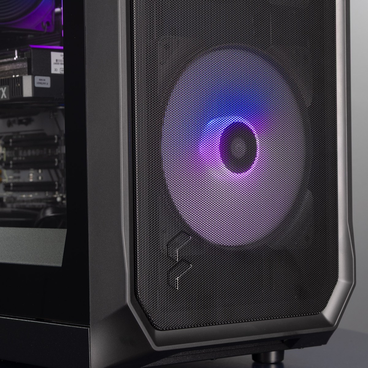 The front of the PC, showing the Fractal logo and one front fan lit up in a blue and purple gradient