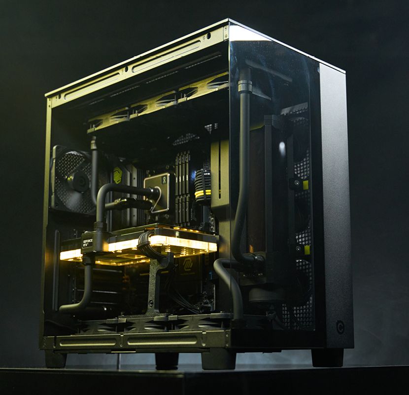 Chillblast Obsidian computer from the Origin range, showcasing an open black chassis with a liquid cooling system, illuminated internal components, and a powerful GeForce RTX graphics card, set against a dark, dramatic backdrop.
