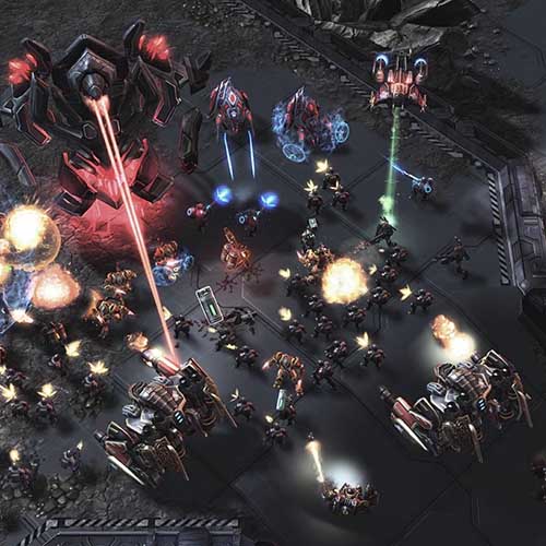 In-game screenshot from StarCraft II showing a large-scale battle between Terran and Protoss units with explosions, lasers, and mechanical armies clashing on a futuristic battlefield.